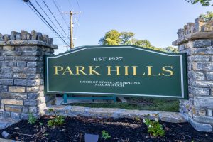 Green Park Hills sign with gold lettering reading 'PARK HILLS' and smaller text 'EST 1927' on a stone pillar entrance.